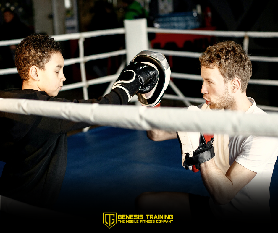 Fitness and boxing coach teaching basics to an enthusiastic young participant during a training session